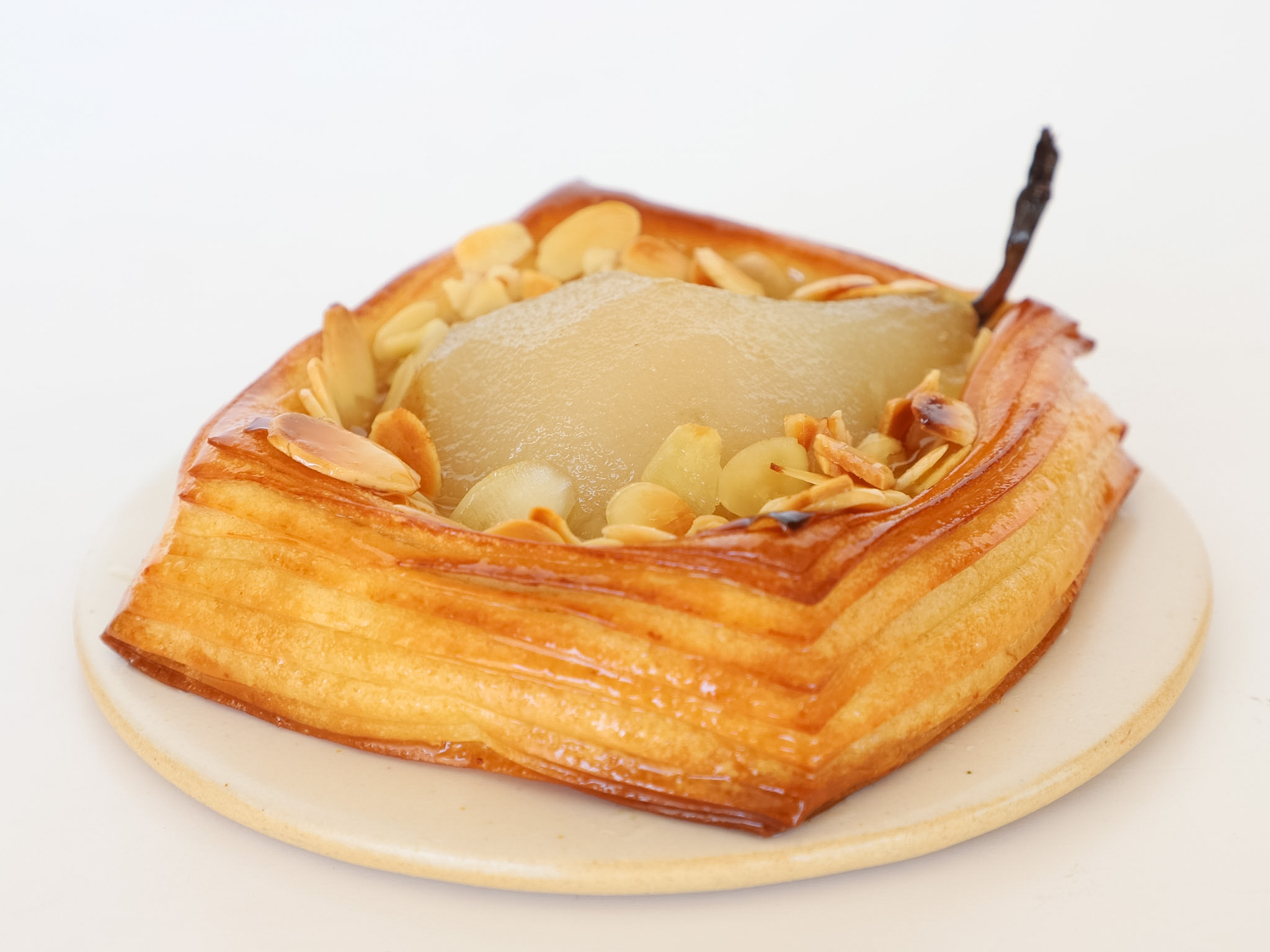 DANESA DE PERA Y ALMENDRAS <br><span style="font-family: 'Spartan', sans-serif;font-size:13px;"><p>Danesa rellena con crema de almendras • Media pera escalfada • Almendras laminadas... </p>$6.500<b>(Por unidad.)</b></span>