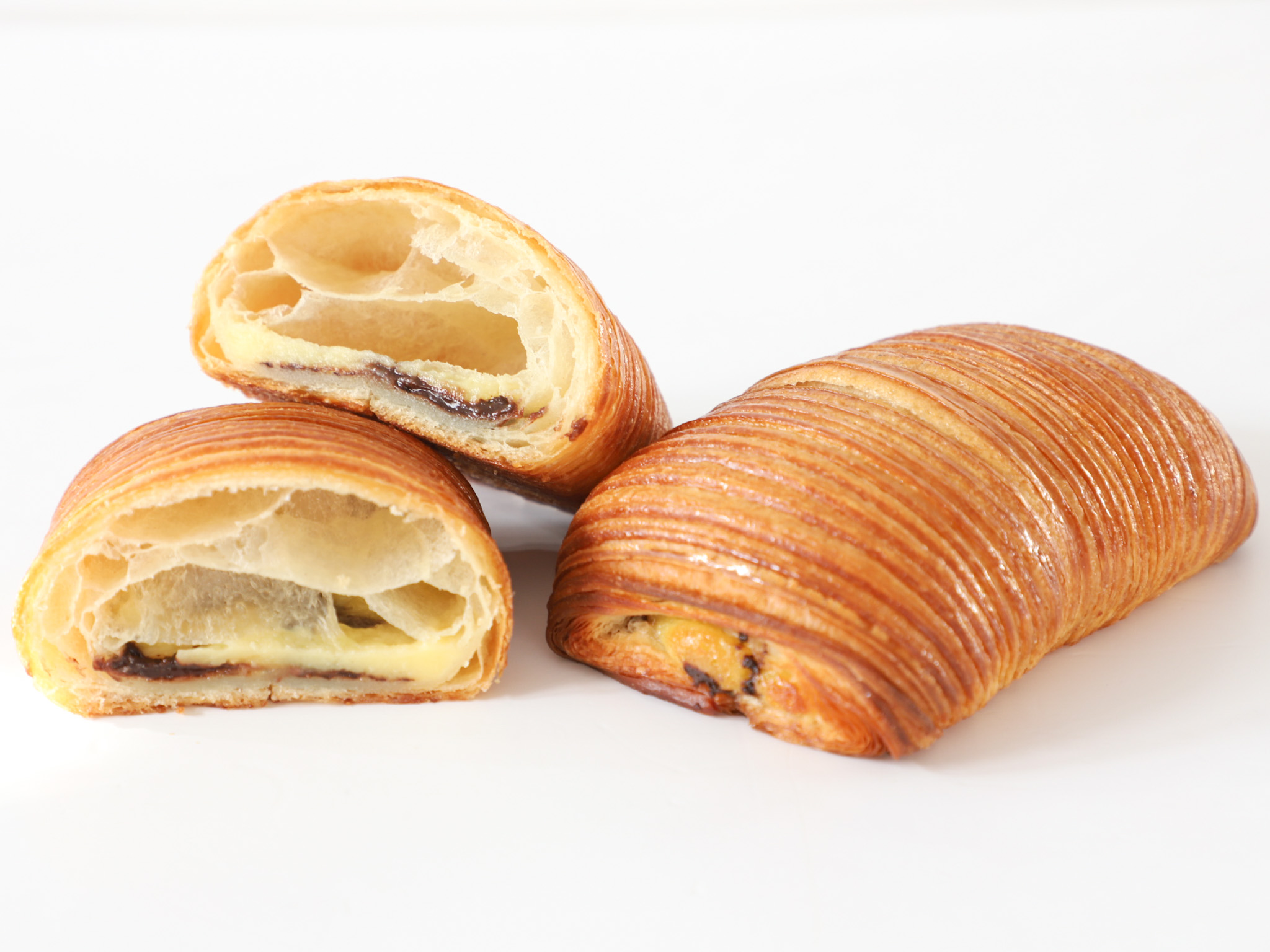 PAN SUIZO DE PASTELERA Y CHOCOLATE <br><span style="font-family: 'Spartan', sans-serif;font-size:13px;"><p>Masa de croissant con interior de crema pastelera de vainilla y chocolate. </p><b>$5.000 (Por unidad.)</b></span>