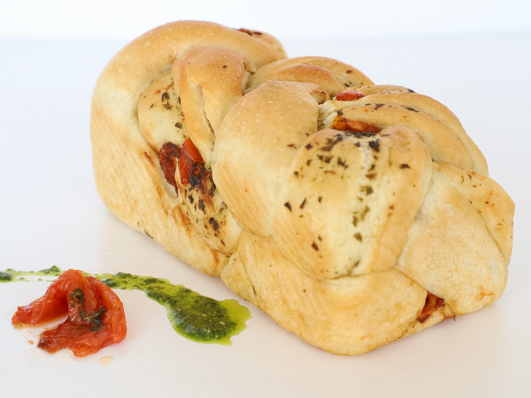 PAN TRENZADO DE PESTO Y TOMATES CONFITADOS<br><span style="font-family: 'Spartan', sans-serif;font-size:13px;"><p>Pan de masa madre con pesto de albahaca y tomates confitados (apto vegano).</p>$7.500<b>(Por unidad - 450 gr.)</b>Disponibles sólo los viernes, sábados, domingos y feriados.</span>